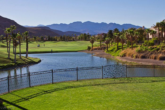 87 Tall Ruff Drive Las Vegas, NV 89148 - Photo 4 of 71 Vistas of a pristine golf course and tranquil lake, with majestic mountains forming a scenic backdrop.