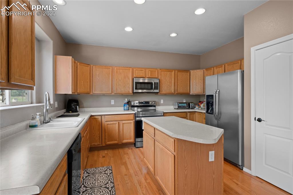 803 Ridgebury Place Fountain, CO 80817 - Photo 21 of 45 a kitchen with stainless steel appliances granite countertop a refrigerator a sink a stove a microwave and island
