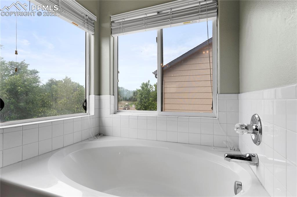 803 Ridgebury Place Fountain, CO 80817 - Photo 32 of 45 a bathroom with bathtub and window