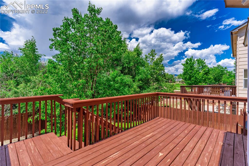 803 Ridgebury Place Fountain, CO 80817 - Photo 8 of 45 a balcony with wooden floor and trees in the back