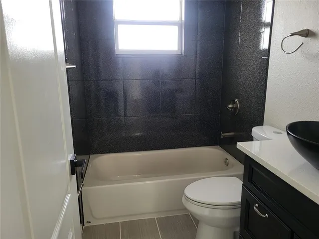 a bathroom with a sink a toilet and bathtub