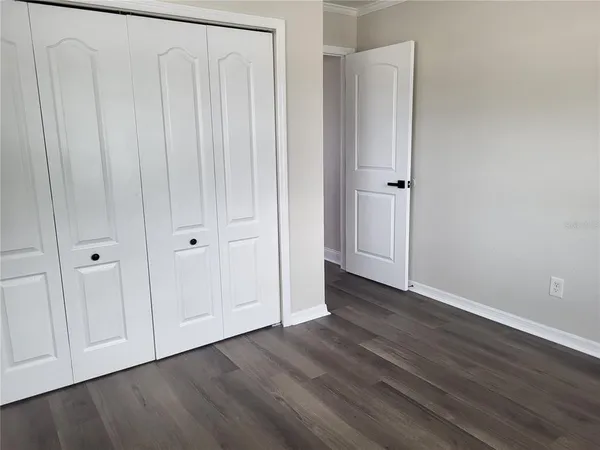 a view of an empty room with wooden floor