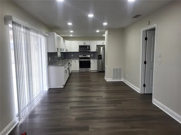 a view of kitchen with wooden floor electronic appliances and window