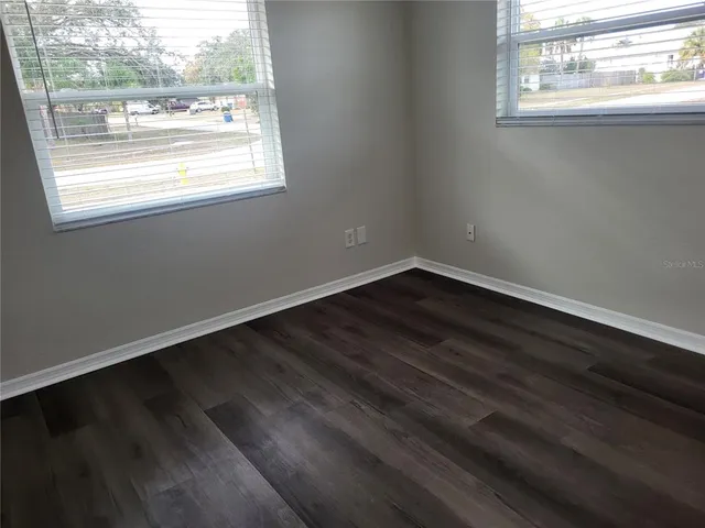a view of a small space with wooden floor and a window