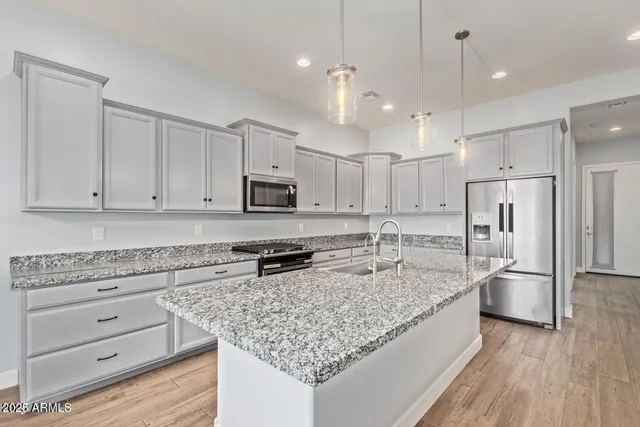 a kitchen with stainless steel appliances granite countertop a sink stove and refrigerator