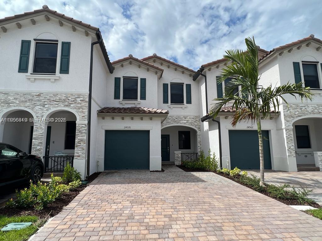 a front view of a house with yard and parking space