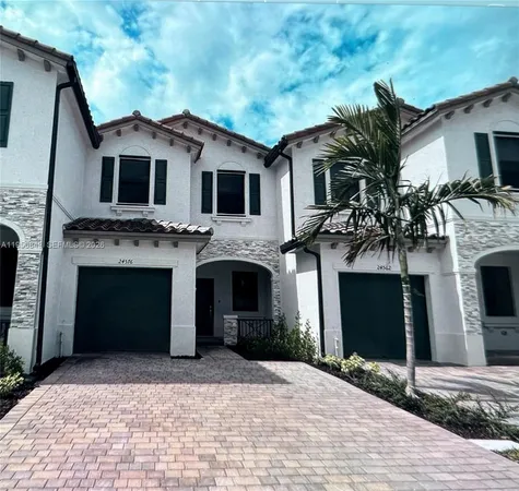 a front view of a house with yard and parking