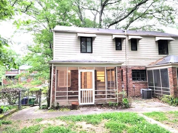 a view of a house with a yard and large tree