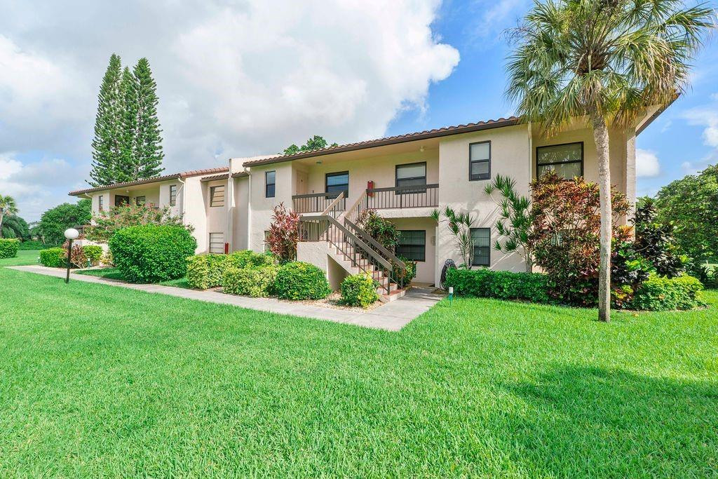 21452 Juego Circle, Unit 31A Boca Raton, FL 33433 - Photo 2 of 38 a front view of house with yard and green space