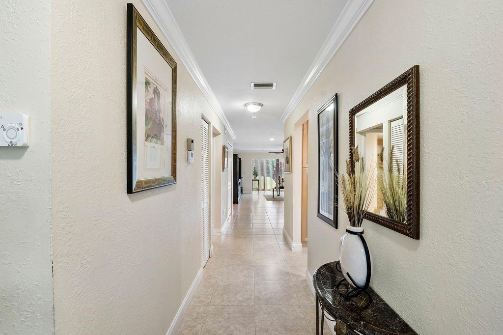 21452 Juego Circle, Unit 31A Boca Raton, FL 33433 - Photo 7 of 38 a hallway with mirror and furniture