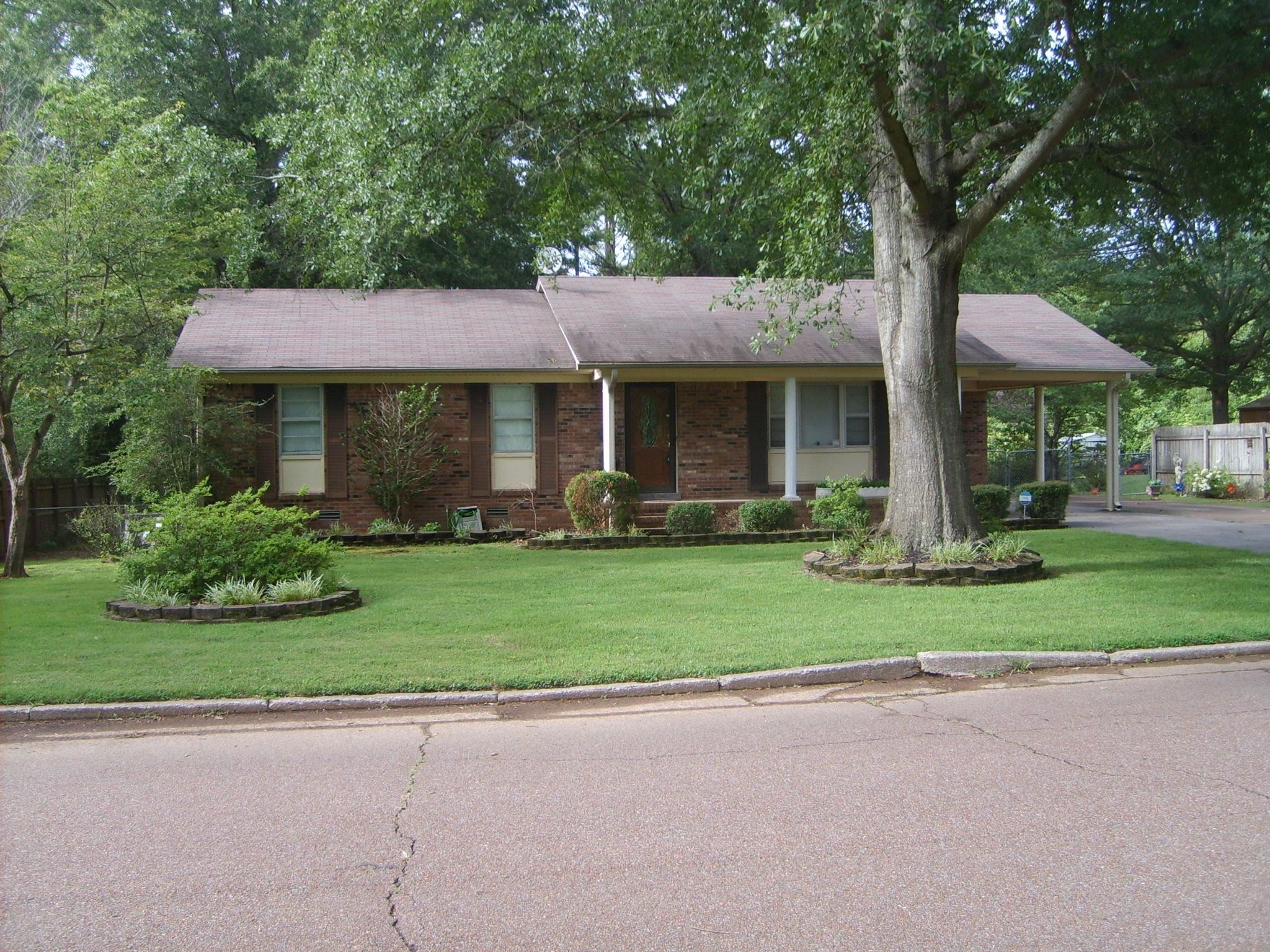 605 Blue Bonnett Road Bolivar, TN 38008 - Photo 2 of 18 a front view of a house with a garden and trees