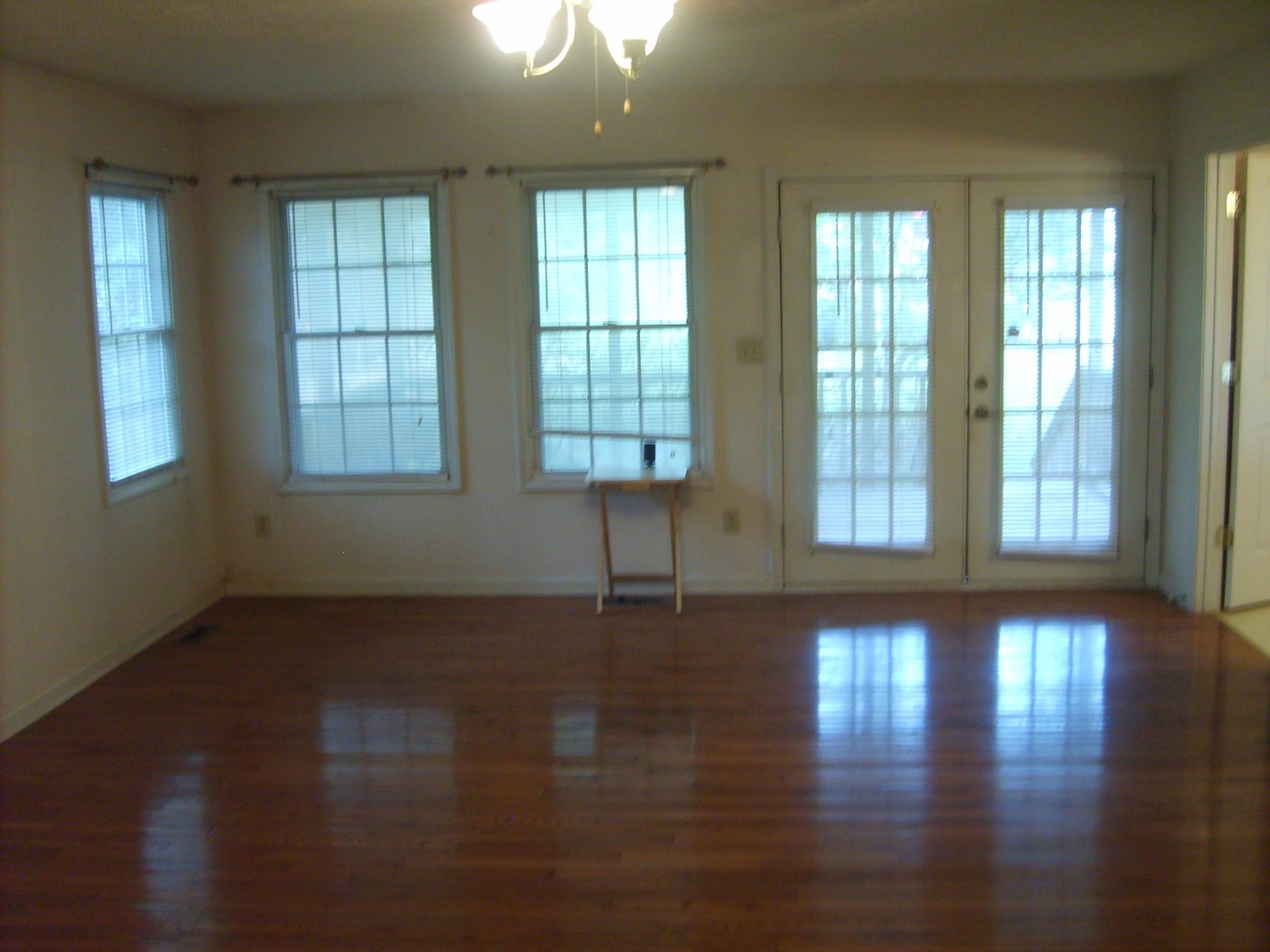 605 Blue Bonnett Road Bolivar, TN 38008 - Photo 10 of 18 an empty room with wooden floor and windows