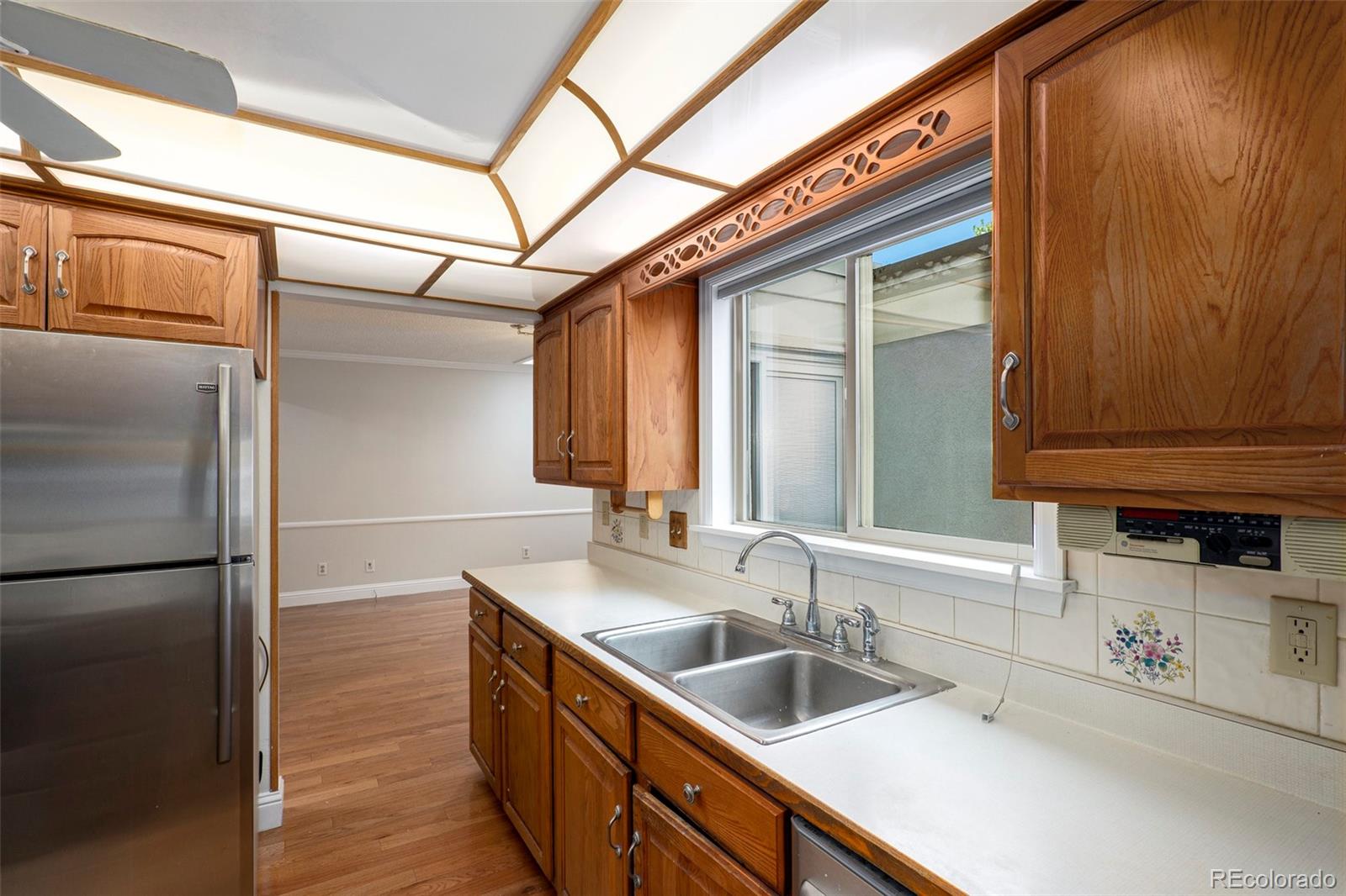 3210 South Oneida Way Denver, CO 80224 - Photo 14 of 28 a kitchen with stainless steel appliances granite countertop a sink and a refrigerator