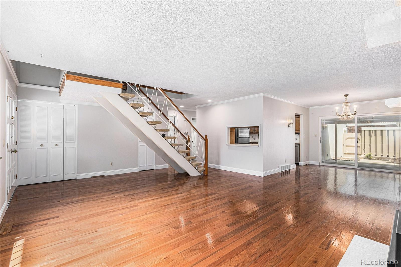 3210 South Oneida Way Denver, CO 80224 - Photo 3 of 28 a view of an empty room with wooden floor and stairs