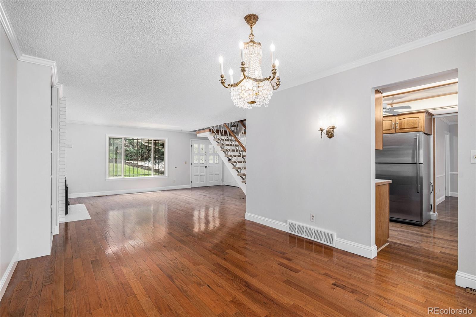 3210 South Oneida Way Denver, CO 80224 - Photo 4 of 28 wooden floor in an empty room with a window