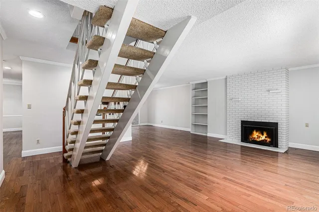 an empty room with wooden floor and a fireplace