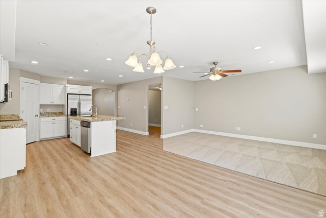 847 225 South Springville, UT 84663 - Photo 6 of 23 Open-concept living area featuring a kitchen with white cabinetry and granite countertops, stainless steel appliances, and a central island with a sink