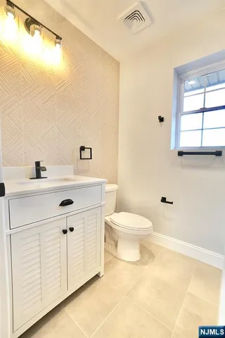 a bathroom with a sink a toilet and vanity