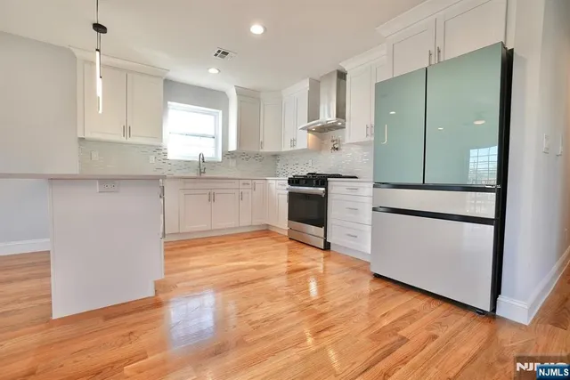 a kitchen with granite countertop stainless steel appliances a refrigerator sink and microwave