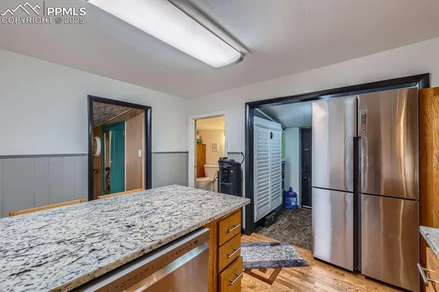 a view of kitchen with granite countertop cabinets and refrigerator