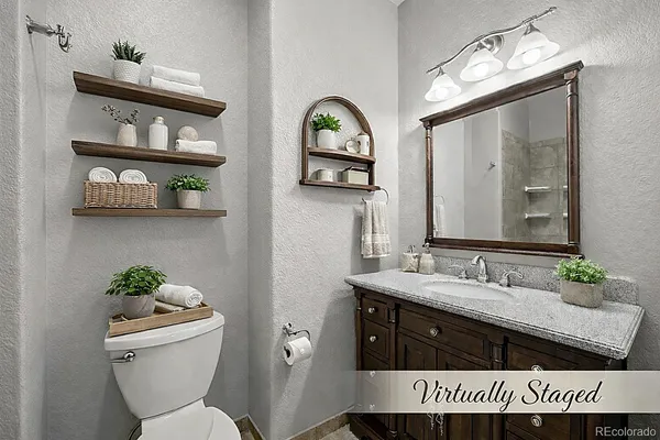 a bathroom with a granite countertop sink a mirror and a shower