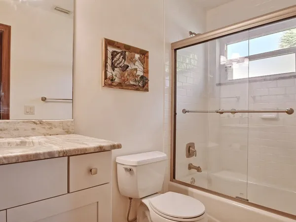 a bathroom with a granite countertop toilet sink and a shower