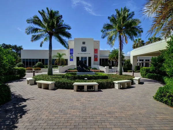 front view of a house with a yard and potted plants