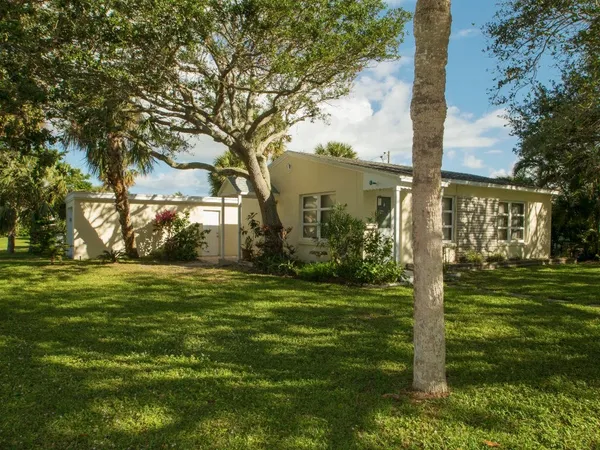 a backyard of a house with lots of green space and fountain in front of it