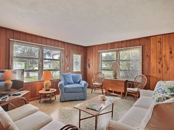 a living room with furniture and floor to ceiling windows