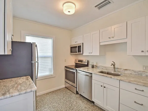 a kitchen with stainless steel appliances granite countertop a sink and a stove