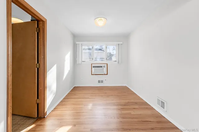 a view of a hallway with wooden floor and a window