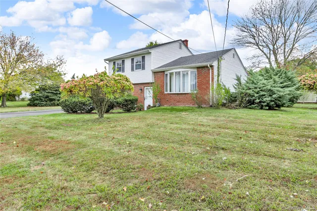 a view of a house with a big yard and large trees