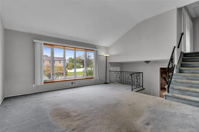 an empty room with furniture and a large window