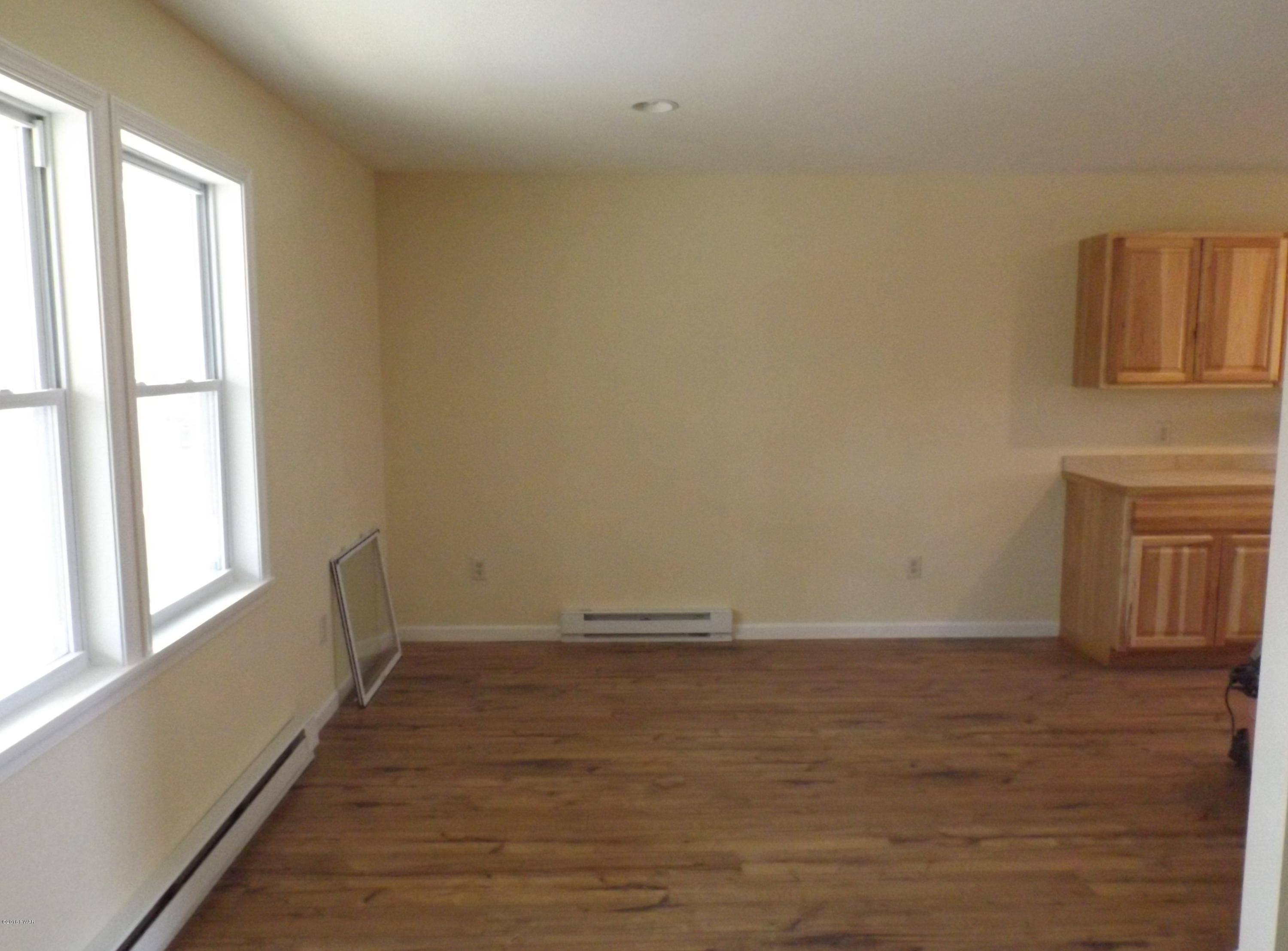 109 Keystone Court Dingmans Ferry, PA 18328 - Photo 3 of 18 a view of an empty room with wooden floor and a window