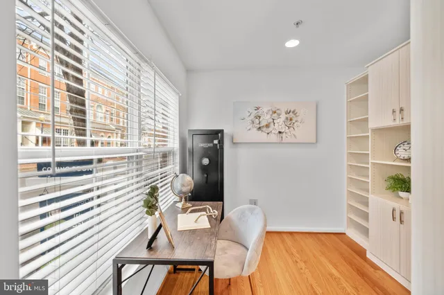 a view of a hallway with wooden floor and workspace