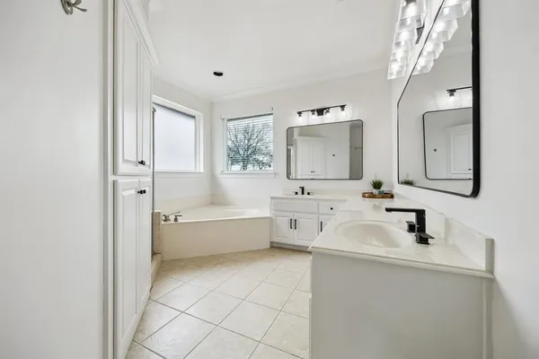 a bathroom with a tub sink and mirror