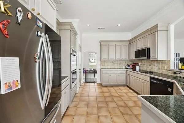 a large kitchen with a stove a sink dishwasher a refrigerator and a microwave