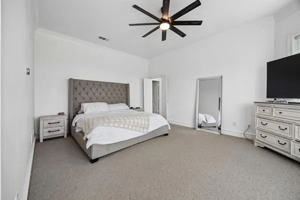 a bedroom with a bed and a flat tv screen on dresser