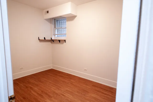 a view of a small space with wooden floor and a window