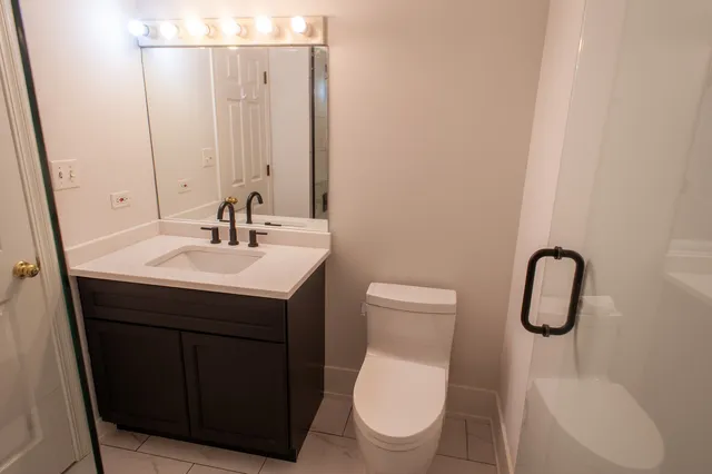 a bathroom with a toilet sink and mirror