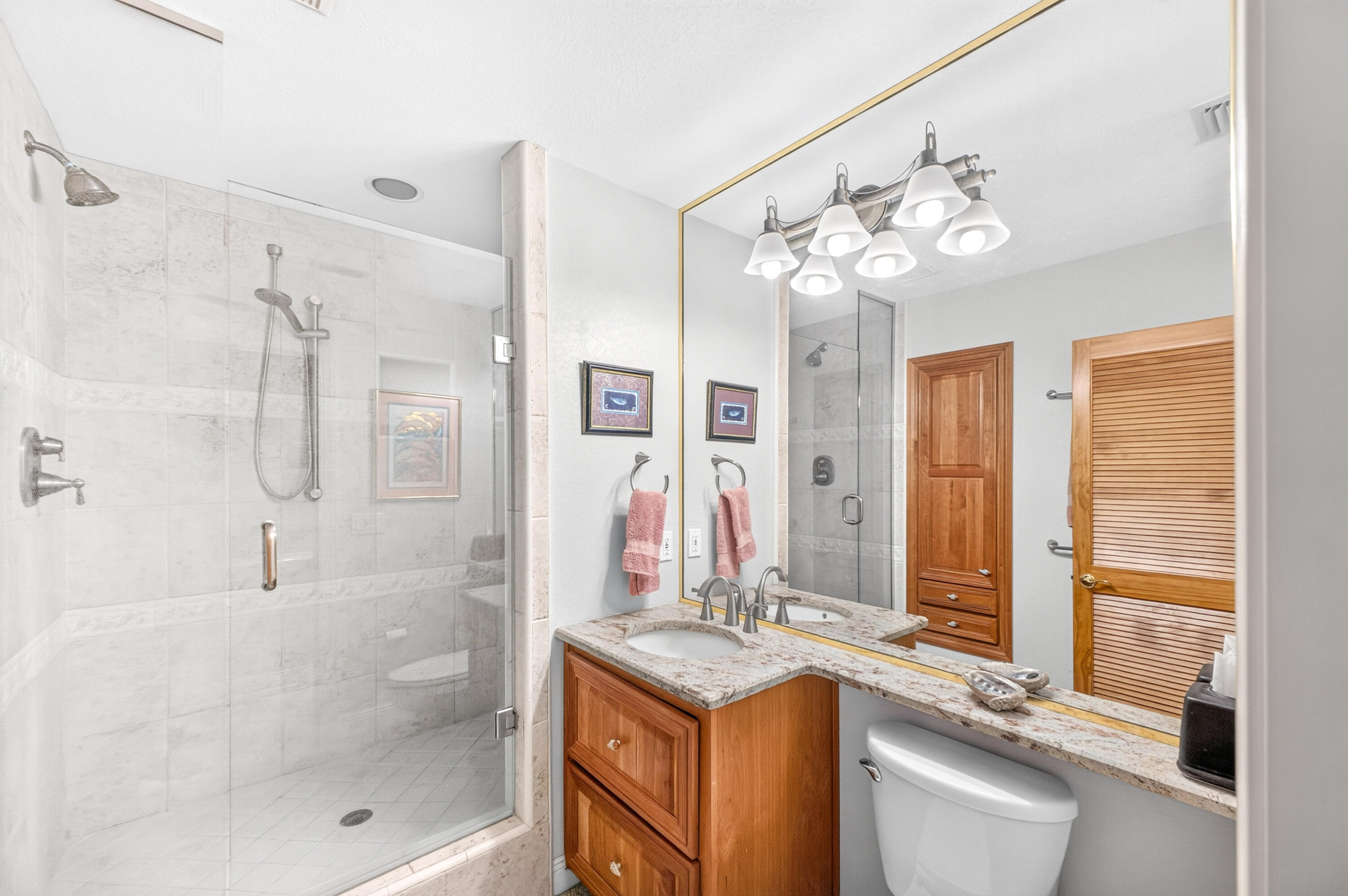 30 Moreno Point Road, Unit 703A Destin, FL 32541 - Photo 39 of 60 a bathroom with a granite countertop sink a large mirror and a shower