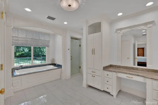 a spacious bathroom with a double vanity sink a large mirror and a bathtub