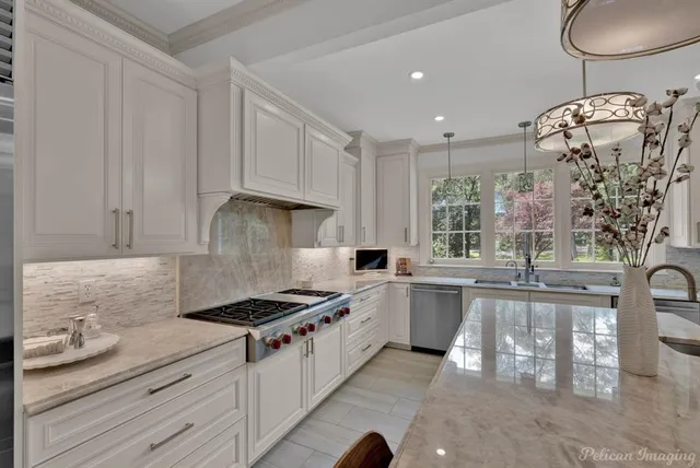a kitchen with stainless steel appliances granite countertop a stove a sink and a white cabinets