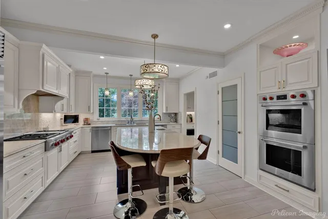 a kitchen with stainless steel appliances kitchen island granite countertop a stove a sink and a refrigerator