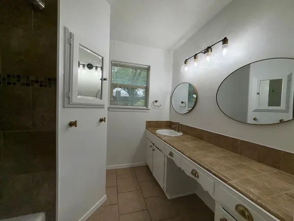 a bathroom with a tub a window and a shower
