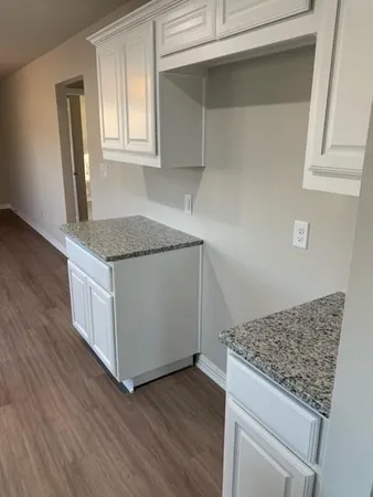 a kitchen with granite countertop a sink and a stove