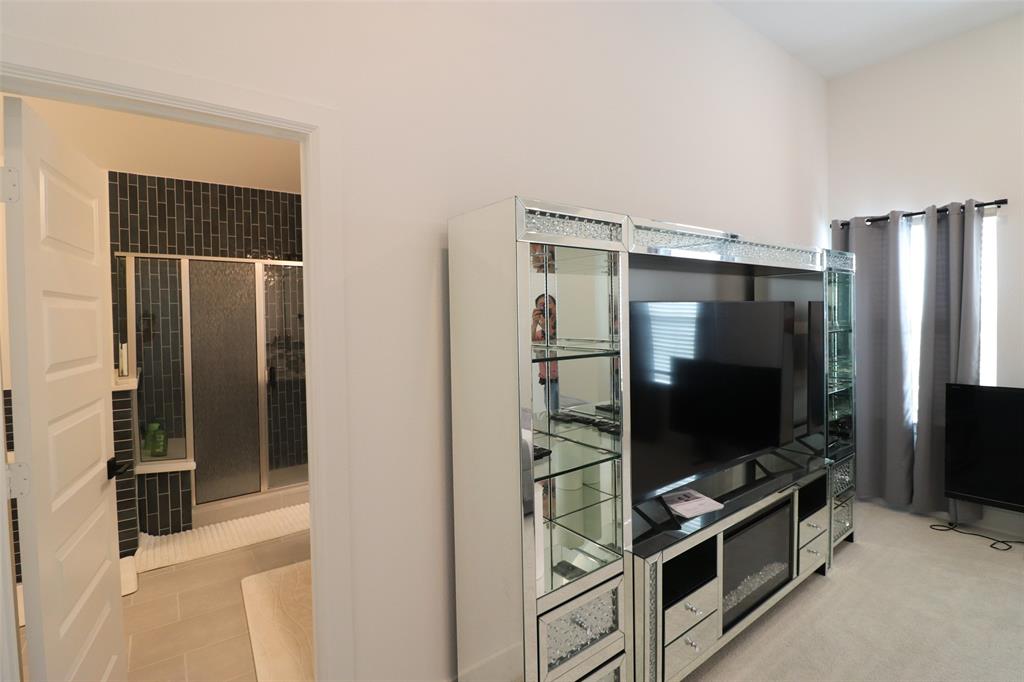 1205 Marc Place Rowlett, TX 75088 - Photo 24 of 30 a living room with flat screen tv and refrigerator