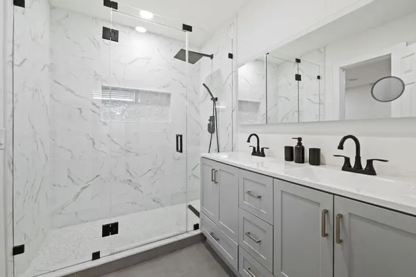 a bathroom with double sink and a shower