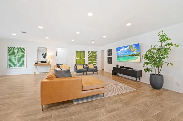 a living room with furniture potted plant and a flat screen tv