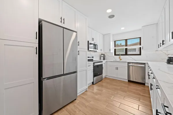 a kitchen with a white refrigerator sink and dishwasher